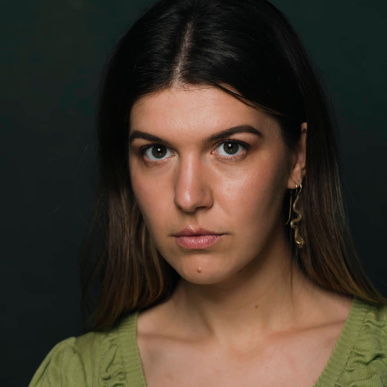 photo of woman in her 20s with dark hair looking intensely at the camera